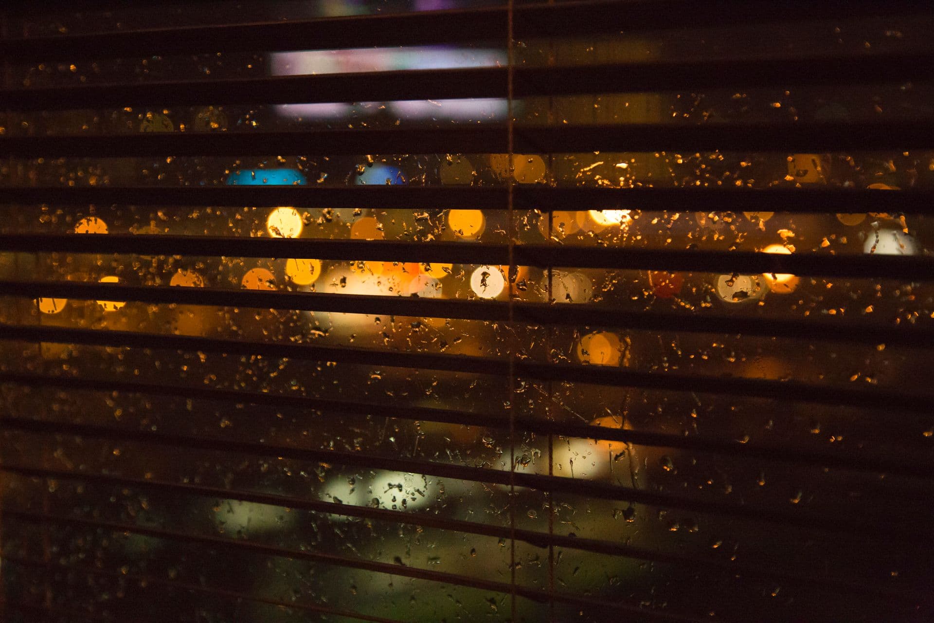 Rain on glass at night with city lights beyond